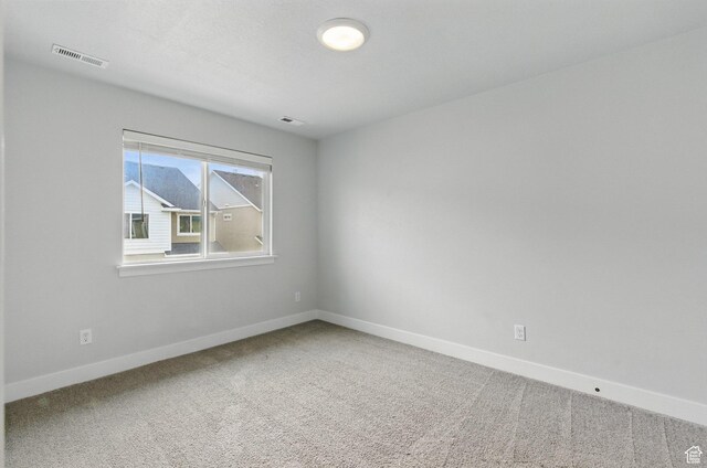 unfurnished room featuring carpet and baseboards