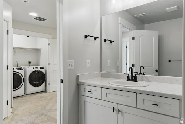 bathroom with independent washer and dryer and vanity