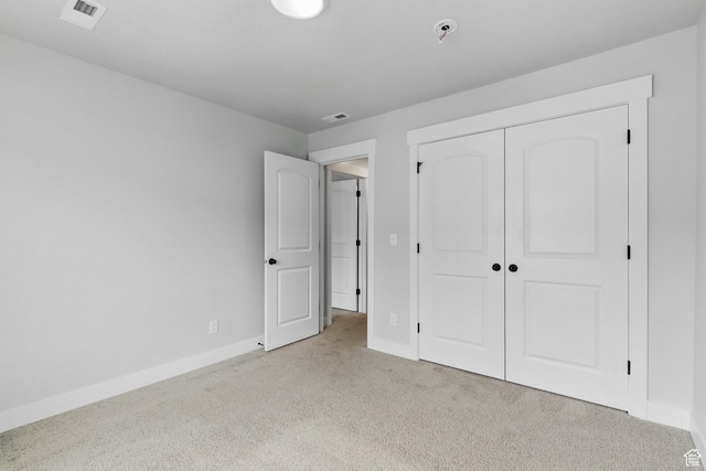 unfurnished bedroom with light carpet, baseboards, and a closet