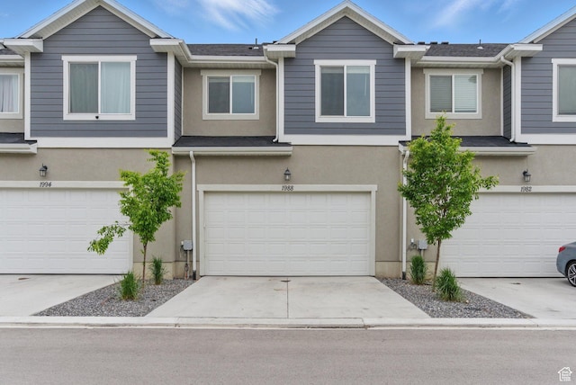multi unit property with stucco siding, a garage, and concrete driveway