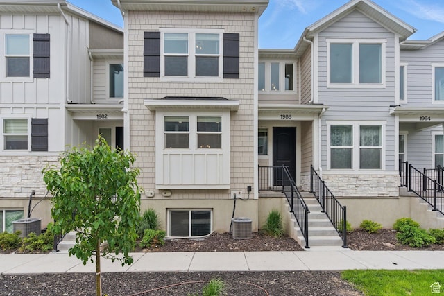 multi unit property featuring stone siding and central AC unit