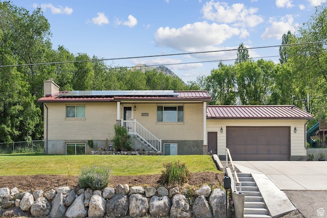 view of front of home featuring solar panels, concrete driveway, a garage, and metal roof
