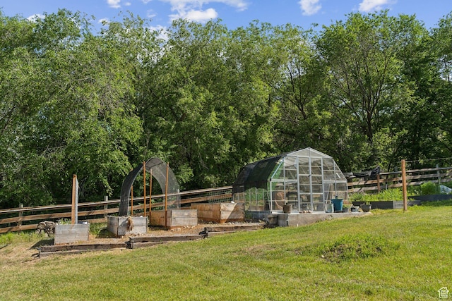 view of yard featuring a vegetable garden, an exterior structure, and an outbuilding