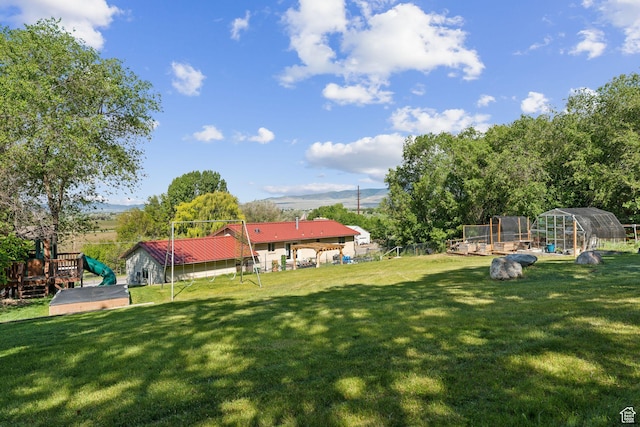 view of grassy yard with an outbuilding and a greenhouse