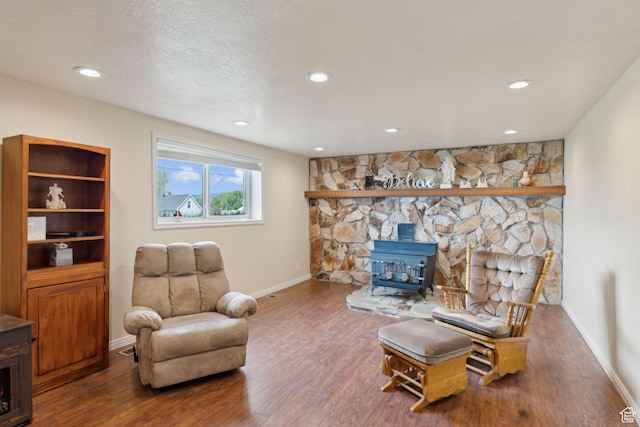 living area with a wood stove, wood finished floors, baseboards, and recessed lighting
