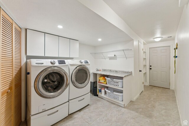 laundry room featuring washing machine and dryer, cabinet space, and recessed lighting