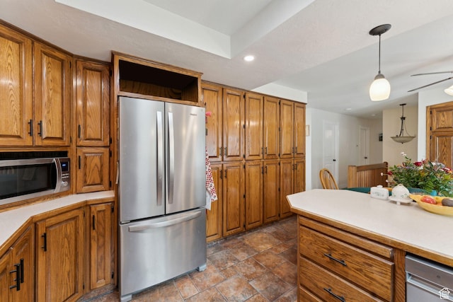 kitchen featuring appliances with stainless steel finishes, brown cabinetry, stone finish flooring, light countertops, and recessed lighting
