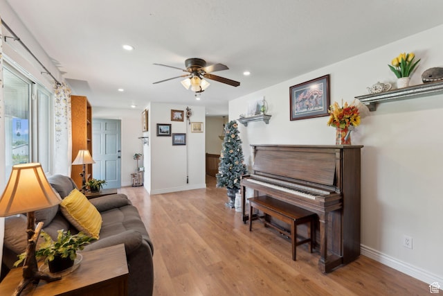 living area featuring baseboards, a ceiling fan, recessed lighting, and light wood finished floors