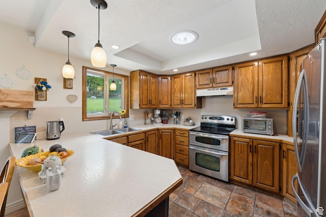 kitchen featuring stainless steel appliances, a sink, a raised ceiling, brown cabinetry, and light countertops
