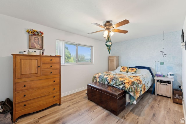 bedroom with light wood finished floors, baseboards, and a ceiling fan