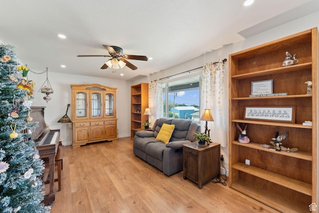 living area with a ceiling fan, light wood-style flooring, recessed lighting, and baseboards