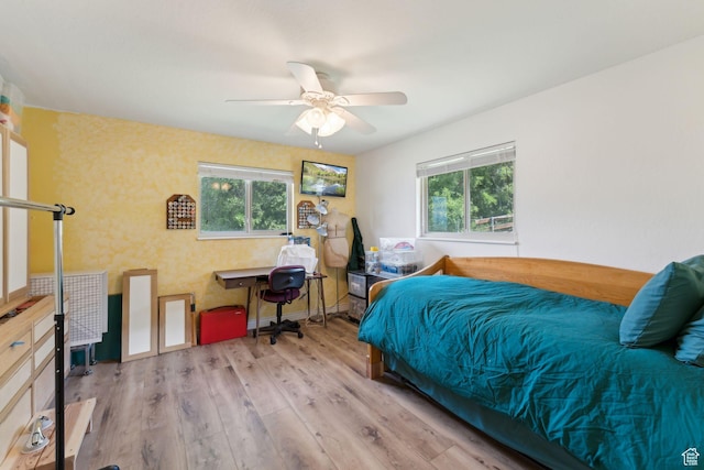 bedroom with wood finished floors, a desk, and ceiling fan