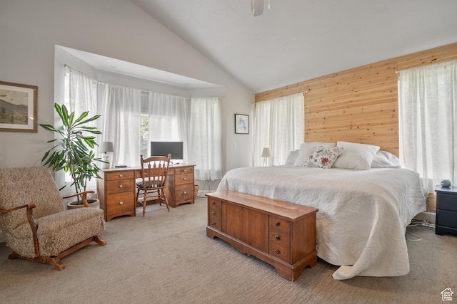 bedroom featuring light carpet, lofted ceiling, and wood walls