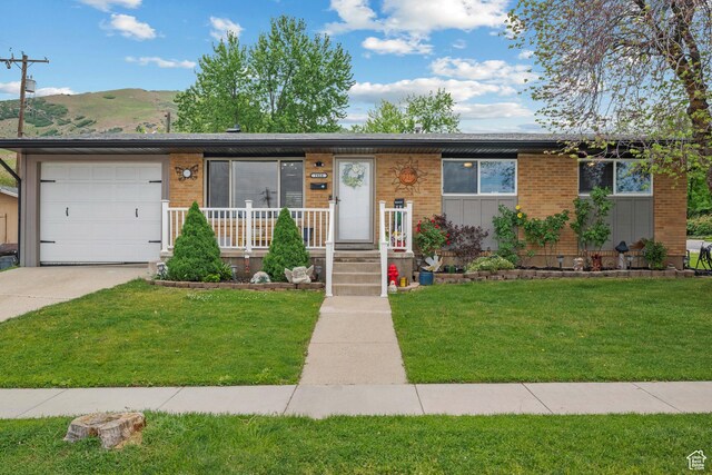 1414 N 325 E, Bountiful, UT 84010 - view of front facade with a mountain view, a front lawn, concrete driveway, an attached garage, and brick siding
