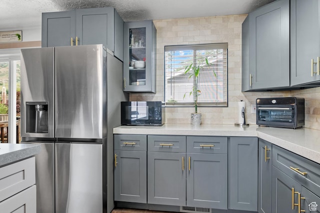 1414 N 325 E, Bountiful, UT 84010 - kitchen with stainless steel refrigerator with ice dispenser, black microwave, light countertops, tasteful backsplash, and a textured ceiling