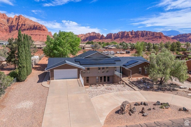 851 E Posado St, Ivins, UT 84738 - view of front of house featuring driveway, a mountain view, solar panels, and a garage