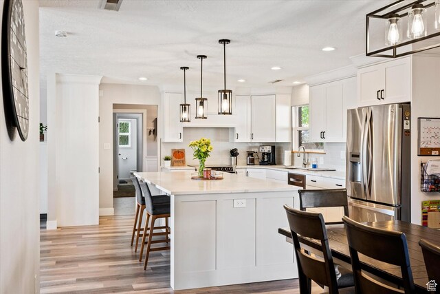 851 E Posado St, Ivins, UT 84738 - kitchen featuring stainless steel refrigerator with ice dispenser, light wood-type flooring, white cabinetry, light countertops, and recessed lighting