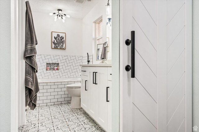 851 E Posado St, Ivins, UT 84738 - full bath featuring tile walls, toilet, tiled bath, vanity, and wainscoting