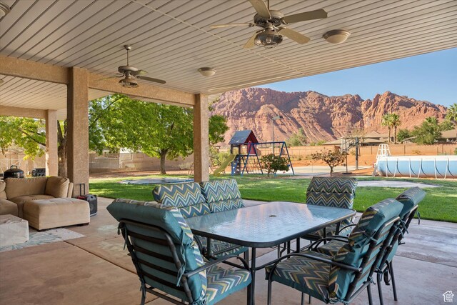 851 E Posado St, Ivins, UT 84738 - view of patio / terrace featuring outdoor dining area, a mountain view, ceiling fan, an outdoor hangout area, and a playground