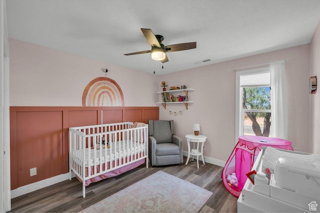 851 E Posado St, Ivins, UT 84738 - bedroom with wood finished floors, a ceiling fan, a wainscoted wall, and a decorative wall