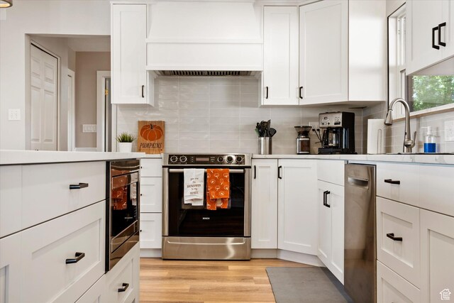 851 E Posado St, Ivins, UT 84738 - kitchen featuring stainless steel appliances, custom exhaust hood, white cabinetry, and backsplash