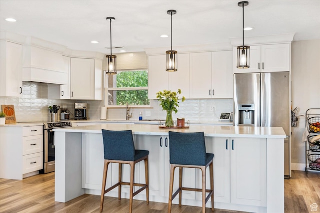851 E Posado St, Ivins, UT 84738 - kitchen with stainless steel appliances, a center island, white cabinets, backsplash, and recessed lighting