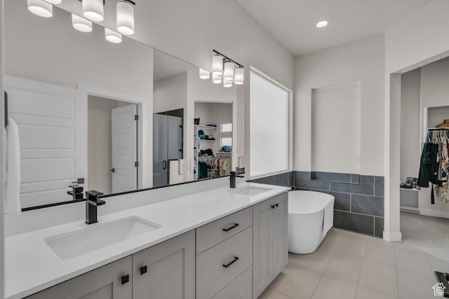 2938 S Poplar Ln, St George, UT 84790 - full bathroom with double vanity, a soaking tub, tile patterned floors, a walk in closet, and wainscoting