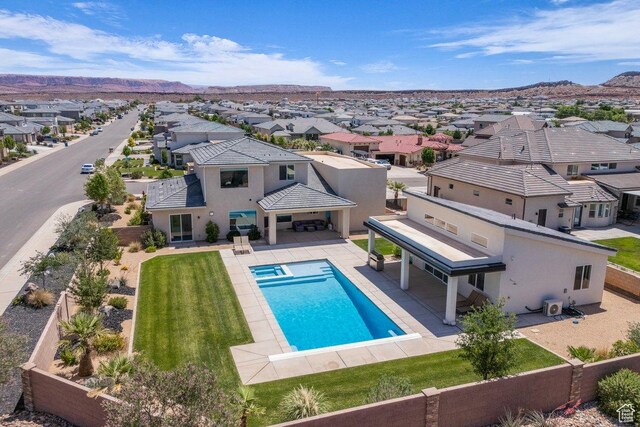2938 S Poplar Ln, St George, UT 84790 - view of swimming pool featuring a residential view, a pool with connected hot tub, a fenced backyard, and a mountain view