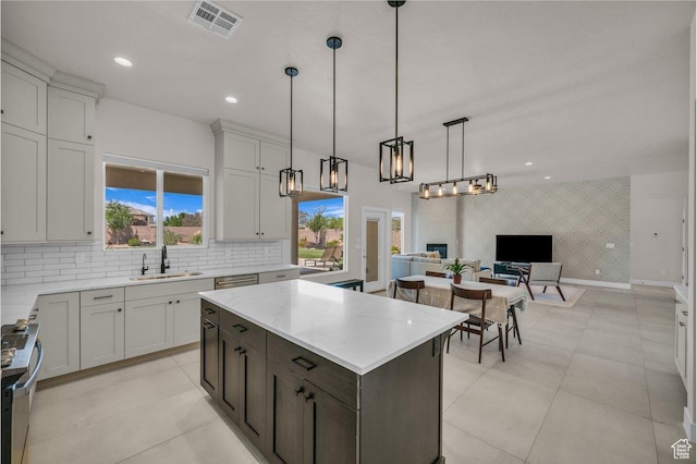2938 S Poplar Ln, St George, UT 84790 - kitchen with a sink, open floor plan, stainless steel electric stove, hanging light fixtures, and decorative backsplash