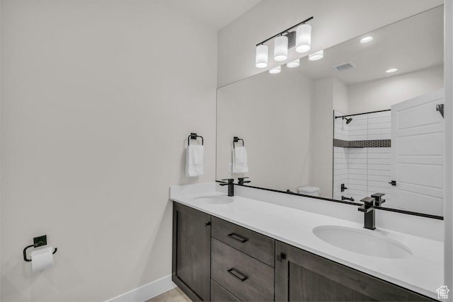 2938 S Poplar Ln, St George, UT 84790 - bathroom with a tile shower, double vanity, baseboards, toilet, and recessed lighting