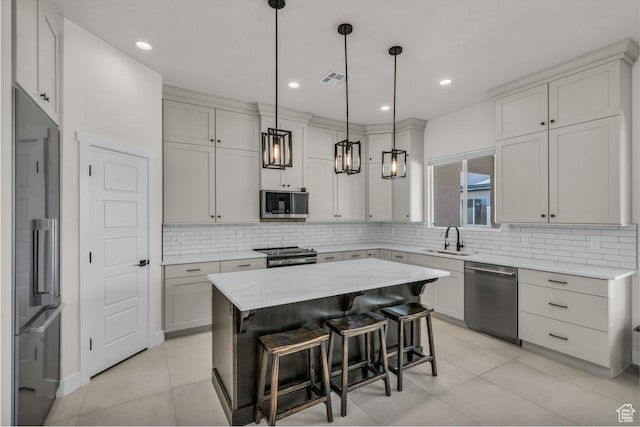 2938 S Poplar Ln, St George, UT 84790 - kitchen featuring stainless steel appliances, a sink, a center island, light tile patterned floors, and backsplash