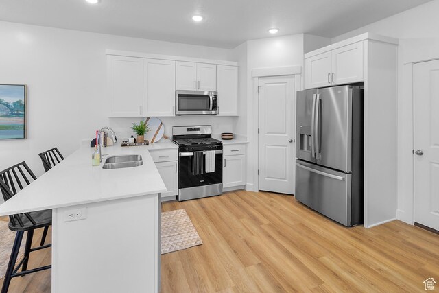 247 W 925 N Unit I49, Brigham City, UT 84302 - kitchen featuring appliances with stainless steel finishes, a sink, a peninsula, a kitchen breakfast bar, and white cabinets