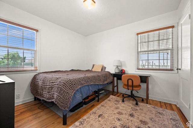 bedroom with baseboards and wood finished floors