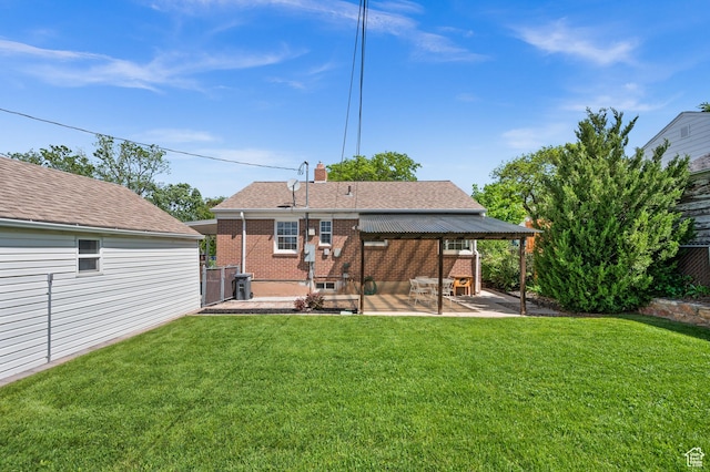rear view of property featuring a patio, brick siding, a chimney, and roof with shingles
