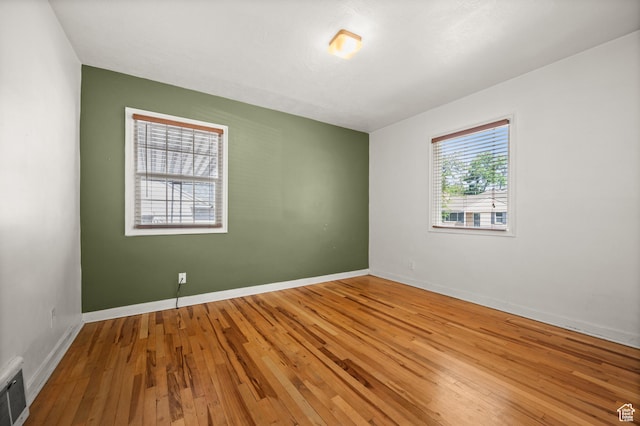 spare room featuring hardwood / wood-style flooring and baseboards