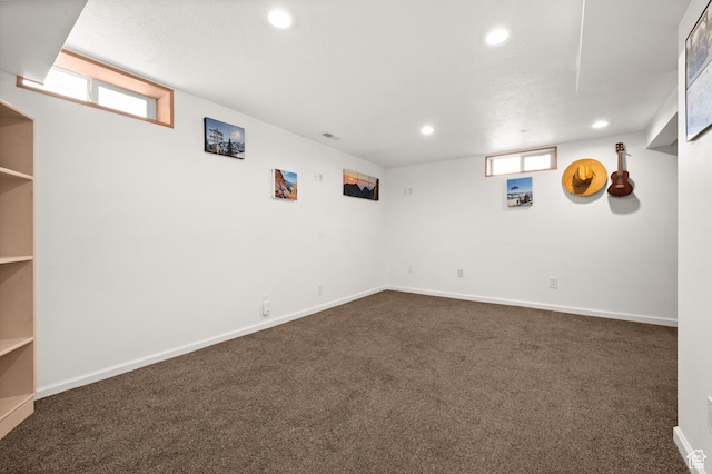 basement with recessed lighting, dark colored carpet, and baseboards