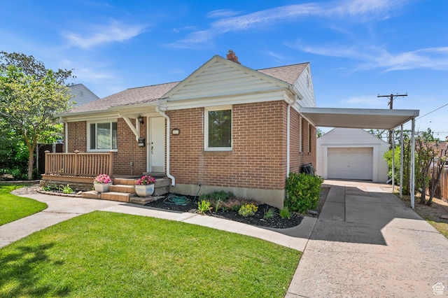 view of front of home with an outbuilding, a front yard, brick siding, and driveway