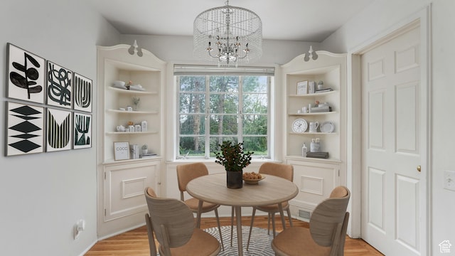 255 N A St E, Salt Lake City, UT 84103 - dining space with a chandelier, built in shelves, and light wood-style floors