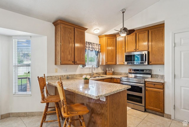 1447 E 230 S, Spanish Fork, UT 84660 - kitchen featuring appliances with stainless steel finishes, a sink, a peninsula, light tile patterned floors, and plenty of natural light