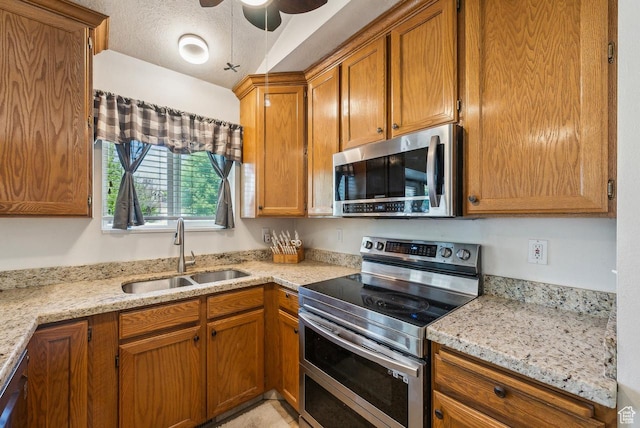 1447 E 230 S, Spanish Fork, UT 84660 - kitchen with appliances with stainless steel finishes, a sink, a ceiling fan, brown cabinetry, and a textured ceiling