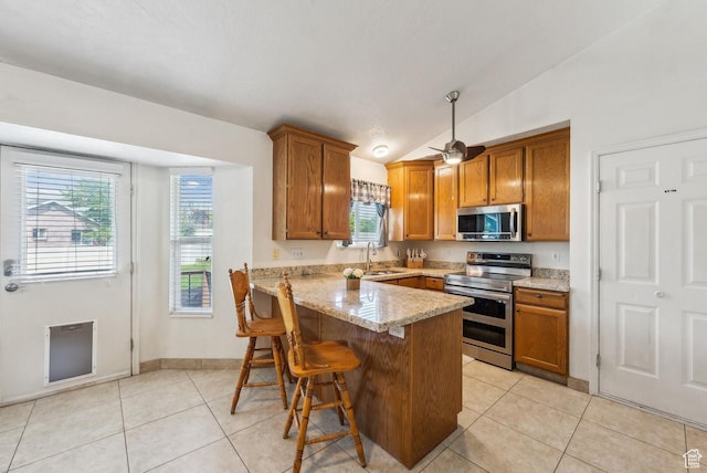 1447 E 230 S, Spanish Fork, UT 84660 - kitchen with stainless steel appliances, brown cabinets, a peninsula, a sink, and healthy amount of natural light