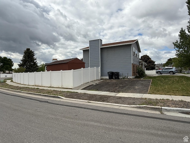 6351 S Moki Cir W, West Jordan, UT 84081 - view of home's exterior with fence and a chimney