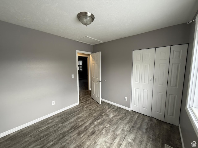 6351 S Moki Cir W, West Jordan, UT 84081 - unfurnished bedroom featuring dark wood-style floors, baseboards, a closet, a textured ceiling, and attic access