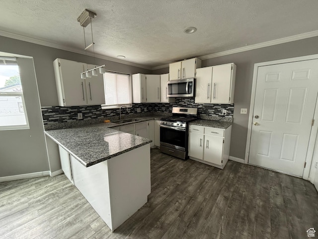 6351 S Moki Cir W, West Jordan, UT 84081 - kitchen featuring appliances with stainless steel finishes, crown molding, a peninsula, backsplash, and dark wood finished floors