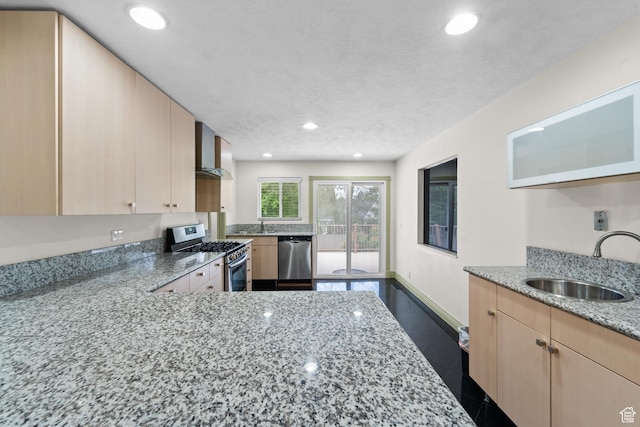 kitchen featuring appliances with stainless steel finishes, a sink, light brown cabinets, light stone counters, and recessed lighting