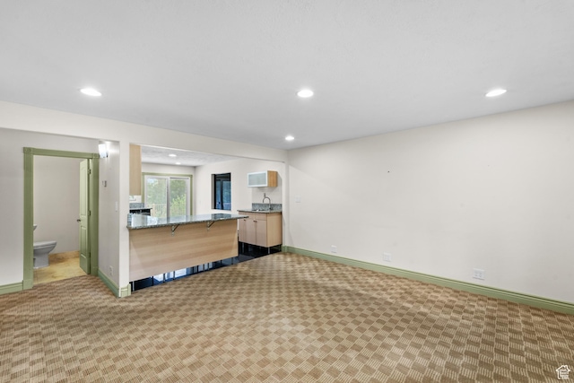 unfurnished living room featuring carpet, recessed lighting, and baseboards