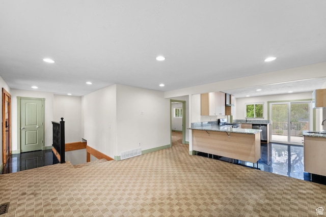kitchen with range, light stone countertops, stainless steel dishwasher, recessed lighting, and a peninsula