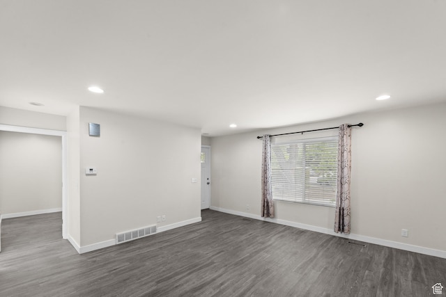 empty room featuring recessed lighting, dark wood-style flooring, and baseboards