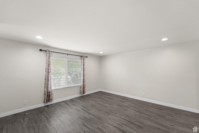 empty room featuring dark wood-style floors, recessed lighting, and baseboards