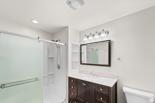 bathroom featuring a stall shower, toilet, and vanity